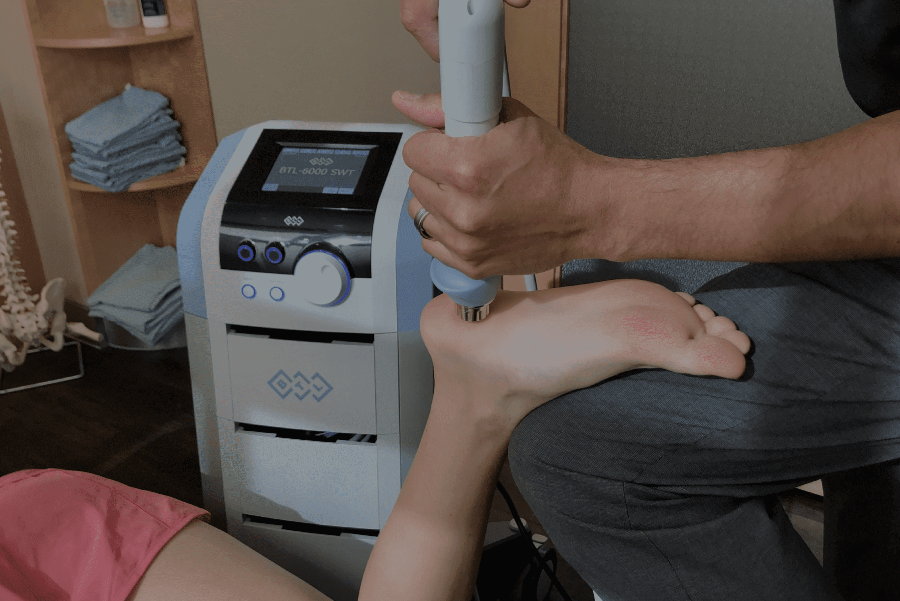 A Woman Is Getting Her Foot Massaged In Shockwave Therapy